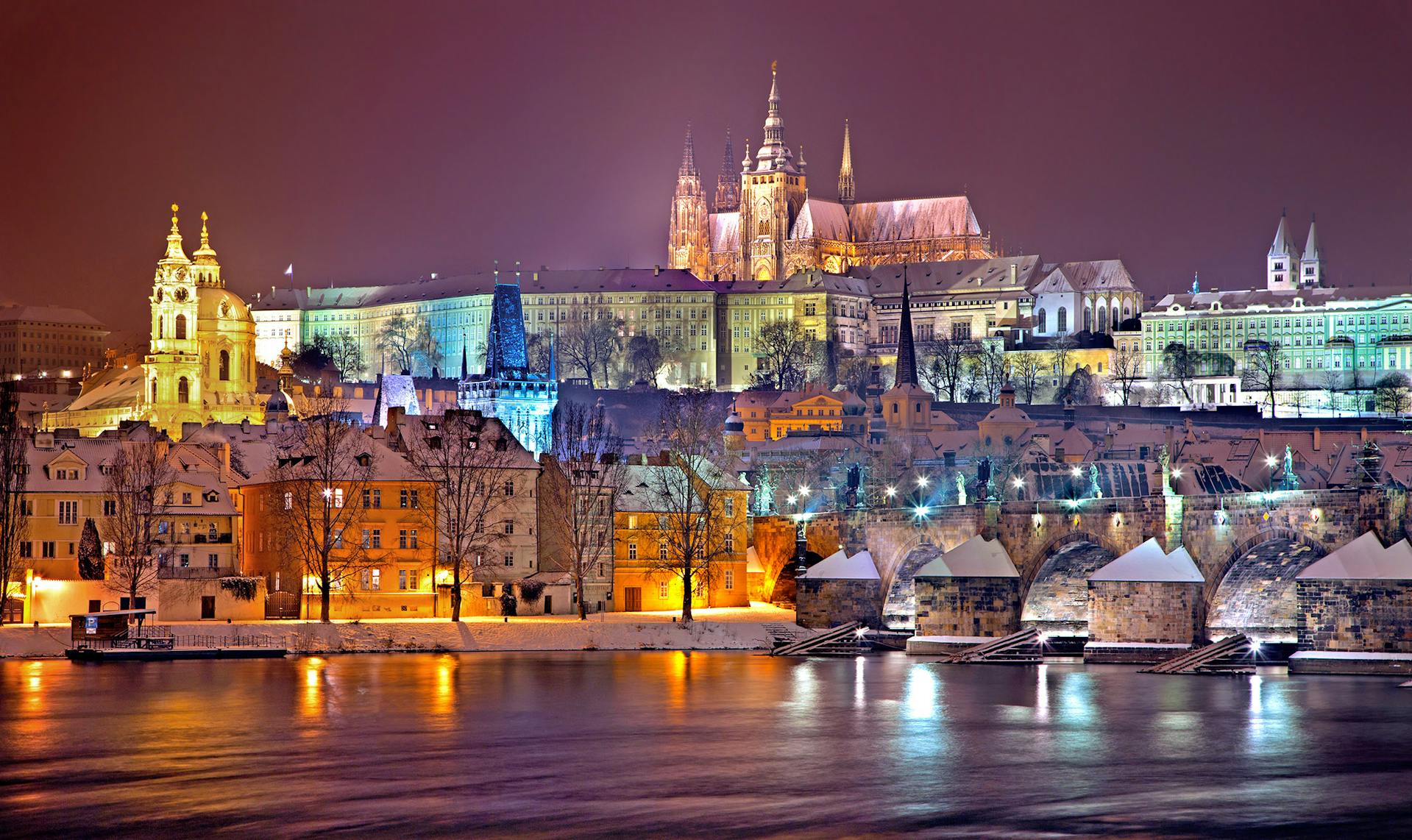 A photo of Prague Castle and Charles' Bridge in the night.